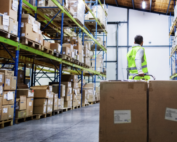 worker in a warehouse carting large boxes